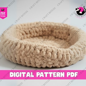 Może przedstawiać: Beżowe, okrągłe łóżko dla zwierząt domowych wykonane na szydełku. Łóżko wykonane jest z grubej, teksturowanej przędzy i ma podwyższoną krawędź. Słowa "DIGITAL PATTERN PDF" są wyświetlane białym tekstem na różowym banerze u dołu obrazu.