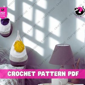 May include: Two hanging crochet storage baskets in white, gray, and purple, with a yellow accent. The image also features a lamp with a gray shade and the text "CROCHET PATTERN PDF".