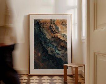 May include: Abstract art print in a gold frame. The artwork features a detailed, textured landscape with shades of brown, blue, and green. The print is displayed in a room with a small wooden side table and a checkered floor.