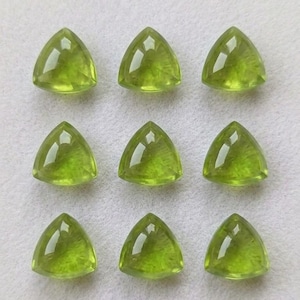 以下が含まれることがあります： 3x3のグリッド状に配置された9個のルースペリドット。各石はファセットカットされた三角形で、鮮やかで半透明のライムグリーン色をしており、光を反射する磨き上げられた表面が特徴です。