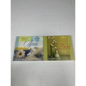 May include: Two Hallmark books with the words "Spa" and "Zen" on the covers. The "Spa" book features a white flower, a bowl, and a jar of salt. The "Zen" book shows a vase with branches and bamboo.