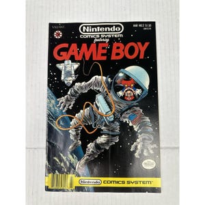 May include: A vintage Nintendo Comics System comic book featuring Game Boy. The cover art depicts an astronaut with a Mario-like character inside the helmet, floating in space with a spaceship. The comic is marked "MAR NO.2 $1.50".