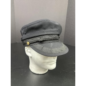 May include: Black sailor hat with a flat top and a short brim. The hat features a decorative rope band and a gold-colored button on the side. The brim has an embroidered design. A small black button is on the top of the hat.