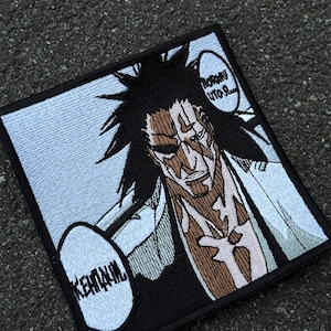 Op de afbeelding: Een vierkante geborduurde patch met een gestileerd anime-personage met stekelig zwart haar en bruine huidmarkeringen. Het personage draagt een lichtgekleurd kledingstuk. Twee tekstballonnen bevatten Cyrillische tekst, "КЕНПАЧИ" en "Потому что я...", tegen een lichtblauwe achtergrond.