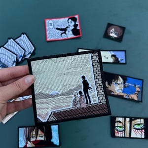 May include: A square embroidered patch featuring a scene of three figures standing on a rooftop looking out at a landscape with a sun, surrounded by various other rectangular and square anime-themed embroidered patches with black borders.