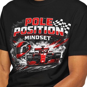 Puede incluir: Camiseta negra con un diseño temático de carreras. El diseño presenta un coche de carreras rojo, un casco y las palabras "POLE POSITION MINDSET" en rojo y blanco. También se incluye una bandera a cuadros.