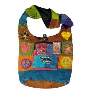 May include: A colorful patchwork shoulder bag with a variety of shapes and symbols. The bag features a peace sign, a heart, and a flower. The bag has the words "SLOW LIFE" on the front and a turtle graphic.