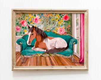 May include: A painting of a brown and white horse lying on a teal green velvet sofa with gold trim. The sofa is in a room with floral wallpaper and a pink curtain.