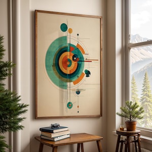 May include: A framed abstract art print featuring a geometric design with concentric circles in teal, orange, and yellow. The artwork is displayed on a wall above a wooden table with books and a camera. The room has a window with a mountain view.