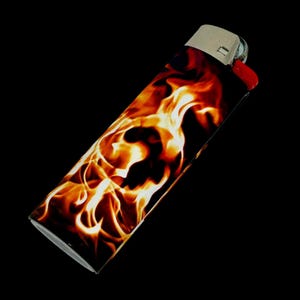 Puede incluir: Un encendedor est&aacute;ndar con un dise&ntilde;o de llamas. El encendedor presenta un patr&oacute;n vibrante de llamas naranjas, amarillas y rojas sobre un fondo negro. La parte superior es plateada con un bot&oacute;n de encendido rojo.