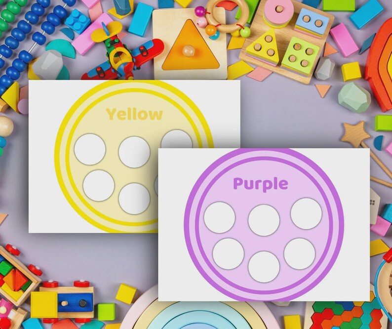 May include: Two educational cards with a circle design and six white circles. One card is yellow with the word "Yellow", and the other is purple with the word "Purple". The cards are surrounded by colorful wooden toys.