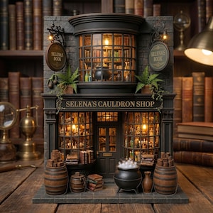 Könnte beinhalten: Ein Miniaturmodell von "Selena's Cauldron Shop" mit dunkler Fassade, beleuchteten Fenstern und einem Schild mit der Aufschrift "Selena's Book". Der Laden verfügt über Fässer, einen Kessel und Bücherstapel. Der Hintergrund ist mit Bücherregalen gefüllt.