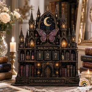 May include: A dark, gothic-style wooden book tracker display featuring a large purple butterfly, a crescent moon, and illuminated towers. The structure includes shelves with miniature books, three number tiles displaying 127, and text reading Books Read This Year and MARILYN'S LIBRARY.