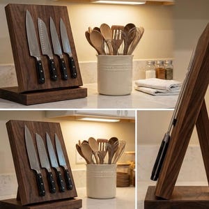 May include: A wooden knife block with a slanted design, holding four stainless steel knives with black handles. The block is made of dark wood and sits on a matching base. Kitchen utensils are in a ceramic container.