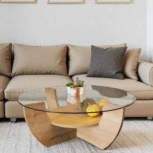 Può includere: Un moderno salotto con un divano componibile beige, un tavolino rotondo in vetro e quattro stampe artistiche astratte incorniciate. Le stampe presentano disegni botanici e geometrici in tonalità neutre, completando l'estetica minimalista della stanza.