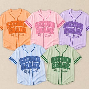 Pode incluir: Cinco camisas de beisebol de manga curta com botões nas cores laranja, rosa, roxo, azul claro e verde claro. Cada camisa apresenta listras verticais e o texto "SECOND GRADE" em fonte varsity, com "Mrs. Smith" escrito abaixo em cursivo.