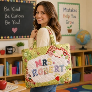 May include: A quilted tote bag featuring a light green fabric with a white polka dot pattern. The center has a white quilted panel with the text "MRS. ROBERT" in colorful, patterned fabric letters, surrounded by decorative star, heart, and swirl appliques.