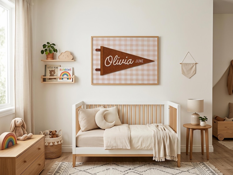 May include: A nursery scene with a white crib, wooden dresser, and a framed pennant that reads "Olivia June." The room has a neutral color palette with a rug, stuffed animals, and decorative shelves.