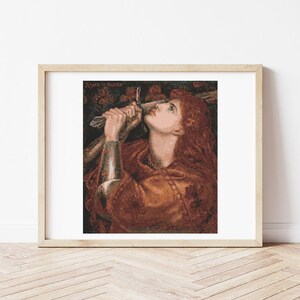 May include: Framed print of a Pre-Raphaelite painting. The artwork depicts a woman with long red hair, gazing upwards while holding a sword. The woman is wearing a brown and gold dress. The frame is a light wood color.