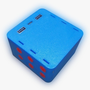 May include: A blue power bank with red circular accents, resembling a die. It has two USB ports and a smaller port on the top. The sides feature red dots. The device is a vibrant blue color.