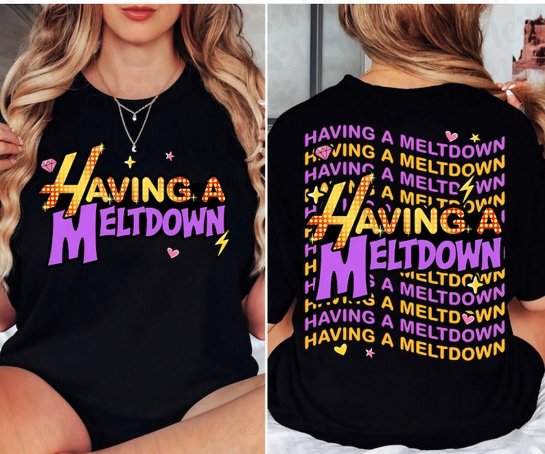 Puede incluir: Camiseta negra con la frase "HAVING A MELTDOWN" en amarillo, naranja y morado. El dise&ntilde;o incluye un diamante, un rayo y corazones. La parte trasera de la camiseta repite la frase.