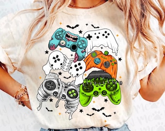 以下が含まれることがあります： ハロウィーンをテーマにしたグラフィックが特徴のクリーム色のTシャツ。デザインには、幽霊、カボチャ、フランケンシュタインのモンスターの形をした漫画スタイルのゲームコントローラーが含まれています。コウモリと星が、お祝いのデザインを完成させています。