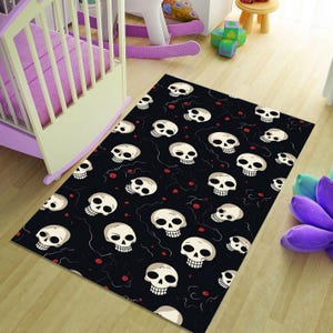 Peut inclure: Tapis rectangulaire noir avec un motif répété de crânes blancs. Les crânes ont des orbites sombres et sont dispersés sur le tapis. Des points rouges et des lignes courbes sont également présents. Le tapis est sur un sol en bois brun clair.