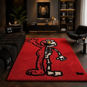 Puede incluir: Una alfombra rectangular roja con un dise&ntilde;o de personaje de dibujos animados con un motivo de esqueleto. El personaje est&aacute; delineado en negro con acentos blancos y beige. La alfombra est&aacute; colocada sobre un suelo de madera oscura en un sal&oacute;n moderno.