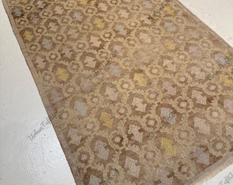 Alfombra Oushak de estilo antiguo: celosía geométrica desgastada, tonos pastel tierra.