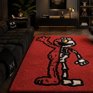 Puede incluir: Una alfombra rectangular roja con un dise&ntilde;o de personaje de dibujos animados con un motivo de esqueleto. El personaje est&aacute; delineado en negro con acentos blancos y amarillos. La alfombra est&aacute; en un sal&oacute;n moderno.