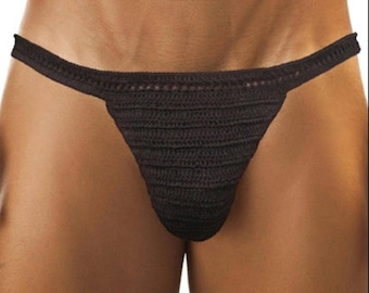 May include: A black crochet thong. The thong features a narrow waistband and a triangular front panel. The crochet work has a textured appearance, with visible stitch patterns. The garment is designed for intimate apparel.