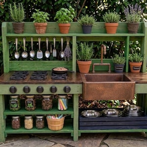 May include: A green wooden play kitchen with a copper sink, stove top, and shelves. It features various potted herbs, hanging utensils, and jars of ingredients. A charming outdoor play set for children.