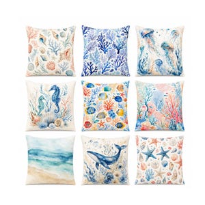 May include: Nine square throw pillows with various watercolor ocean-themed designs. Pillows feature images of seashells, coral, seahorses, fish, jellyfish, whales, and starfish in shades of blue, beige, and coral.