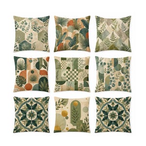 Könnte beinhalten: Neun dekorative Zierkissen mit verschiedenen botanischen und geometrischen Designs. Die Kissen weisen Farbtöne von Grün, Beige und Orange auf. Zu den Designs gehören Blätter, Farne und geometrische Muster. Die Kissen sind quadratisch und scheinen aus Stoff zu sein.