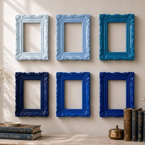 May include: Six rectangular picture frames arranged in two rows of three on a wall. The frames feature ornate, carved detailing and are painted in a gradient of blue shades, ranging from a pale sky blue to a deep, dark navy blue.