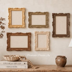 May include: Five ornate rectangular picture frames in varying shades of gold, beige, and brown are arranged on a wall. Below, a stack of two books labeled Live Beautifully and This Is Home sits next to a ceramic bowl, beads, and a small vase.