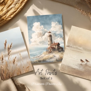 May include: A set of three rectangular art prints featuring coastal scenes. One print shows tall beach grass, another depicts a lighthouse on a rocky shore under a cloudy sky, and the third shows two small birds on a sandy beach. Text reads Art Prints Set of 3 Printable Palette Joy.