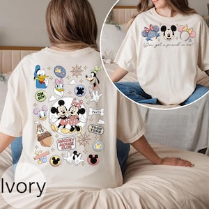 Op de afbeelding: Ivoor t-shirt met Mickey en Minnie Mouse, andere Disney-personages en de tekst "You got a friend in me!". De achterkant van het shirt heeft Disney-graphics en de woorden "Mickey Mouse Club".
