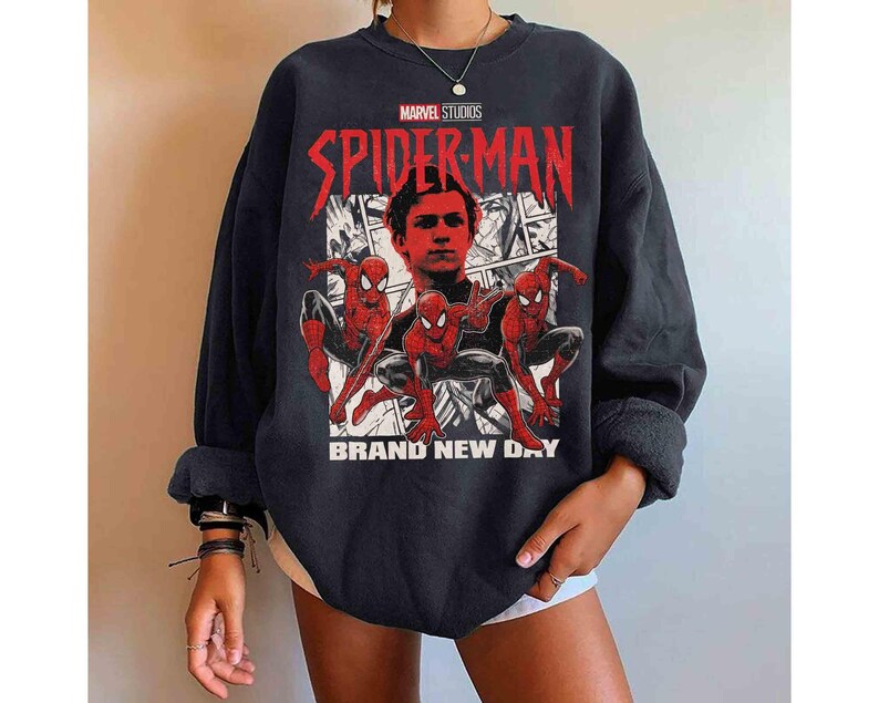 Puede incluir: Sudadera negra con un dise&ntilde;o de Spider-Man. El texto "SPIDER-MAN" es rojo y "BRAND NEW DAY" es blanco. El logotipo de Marvel Studios est&aacute; en la parte superior. El dise&ntilde;o incluye im&aacute;genes de Spider-Man en acci&oacute;n.