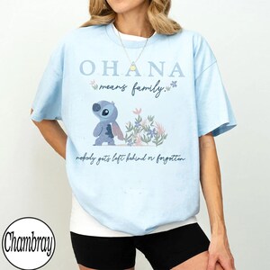 May include: Light blue t-shirt with the text "OHANA means family." and a cartoon character illustration. The shirt also has the phrase "nobody gets left behind or forgotten."