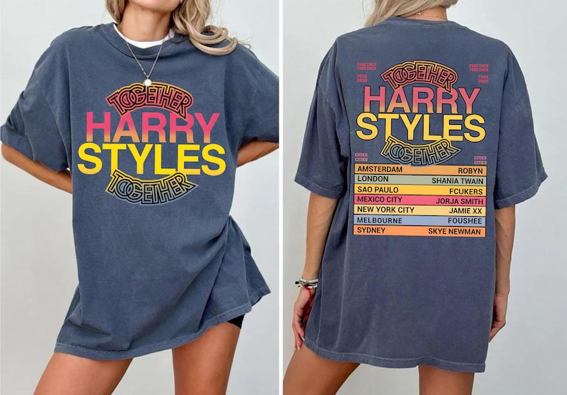 Pu&ograve; includere: Una t-shirt blu scuro con una grafica sul davanti e sul retro. La parte anteriore mostra il testo "TOGETHER HARRY STYLES" in un design circolare. Il retro elenca citt&agrave; del tour e nomi tra cui "AMSTERDAM," "LONDON" e "HARRY STYLES."