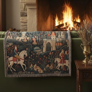 Può includere: Una coperta arazzo con una scena di castello medievale nei toni del blu, rosso e verde è drappeggiata su un divano verde. La coperta presenta figure a cavallo e un design dettagliato del castello. Un camino con fuoco acceso è sullo sfondo.