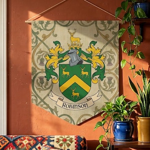 May include: A decorative wall hanging featuring a family crest with the name "Robinson" on a banner. The crest includes a shield with deer and a yellow chevron, set against a patterned background. The banner is suspended from a wooden rod.