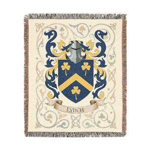 May include: Cream-colored throw blanket with a family crest design. The crest features a blue shield with gold chevron and shamrocks, a silver helmet, and blue and gold decorative elements. The word "Lynch" is on a banner.