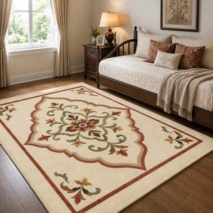 May include: A rectangular area rug featuring a cream-colored base with a central medallion design in shades of rust red, olive green, and tan. The rug includes a decorative border and floral motifs in the corners, all set on a wooden floor.