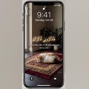 Puede incluir: Pantalla de smartphone que muestra un fondo de pantalla con un gato sobre una alfombra estampada. La pantalla muestra la hora 9:41 y la fecha lunes 26 de octubre. También se ve texto árabe y una traducción al inglés de un versículo del Corán.