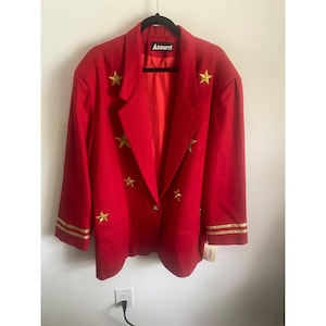 May include: A bright red blazer featuring a single-button closure, notched lapels, and long sleeves with two gold-toned stripes at each cuff. The garment is decorated with multiple gold-toned star appliqués and has an Azzurri brand label inside.