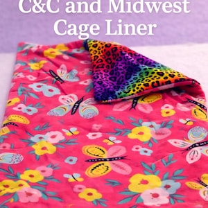 May include: A custom-made cage liner with a vibrant pink floral and butterfly pattern. The liner features a folded-over section with a rainbow leopard print. Text on the image reads "Custom Made C&C and Midwest Cage Liner."