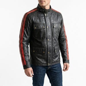 May include: A black leather jacket with red stripes on the sleeves. The jacket features a stand-up collar, four front pockets, and a button-up closure. The person is wearing blue jeans.