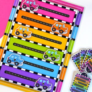 May include: A children's toy with a clear plastic frame, showcasing six horizontal tracks in vibrant colours. Each track features a cartoon car sticker. Car-themed keychains are also visible.